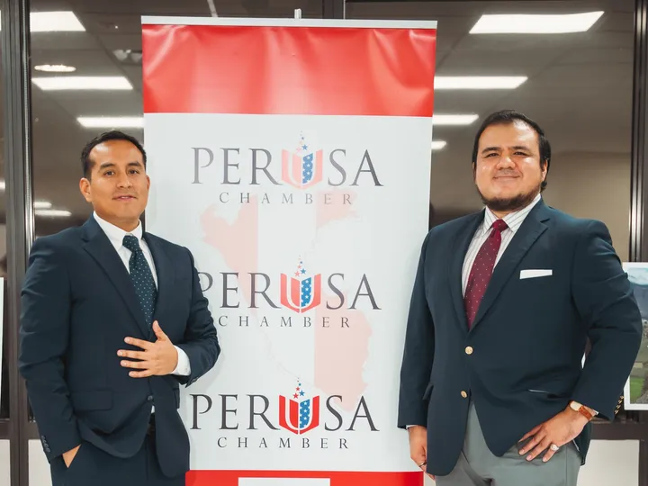 Dos representantes junto a un banner de PERUSA Chamber.